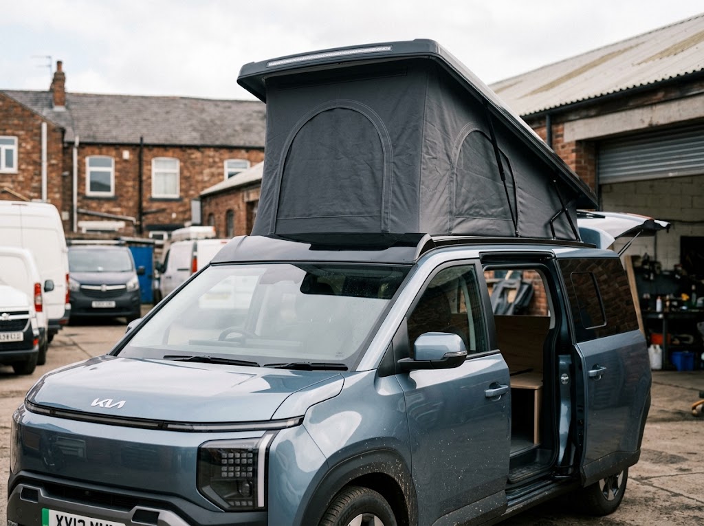 Kia PV5 with elevating roof raised and side door open showing ply furniture