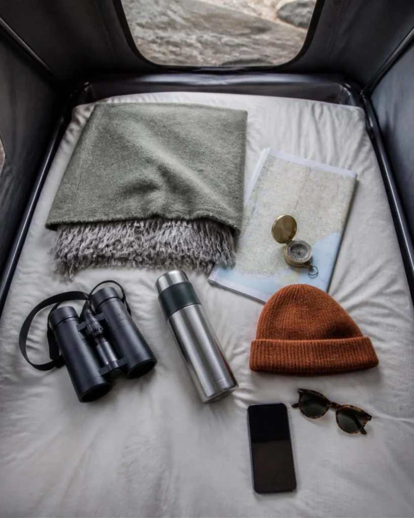Pop top roof bed with blanket, map, flask and binoculars